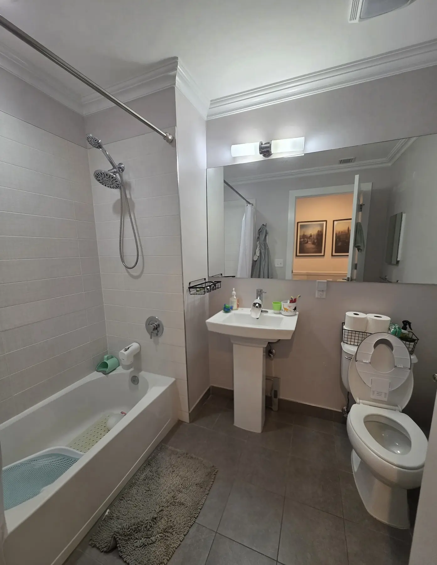 The first bathroom before work began, with a pedestal sink and dated tile
