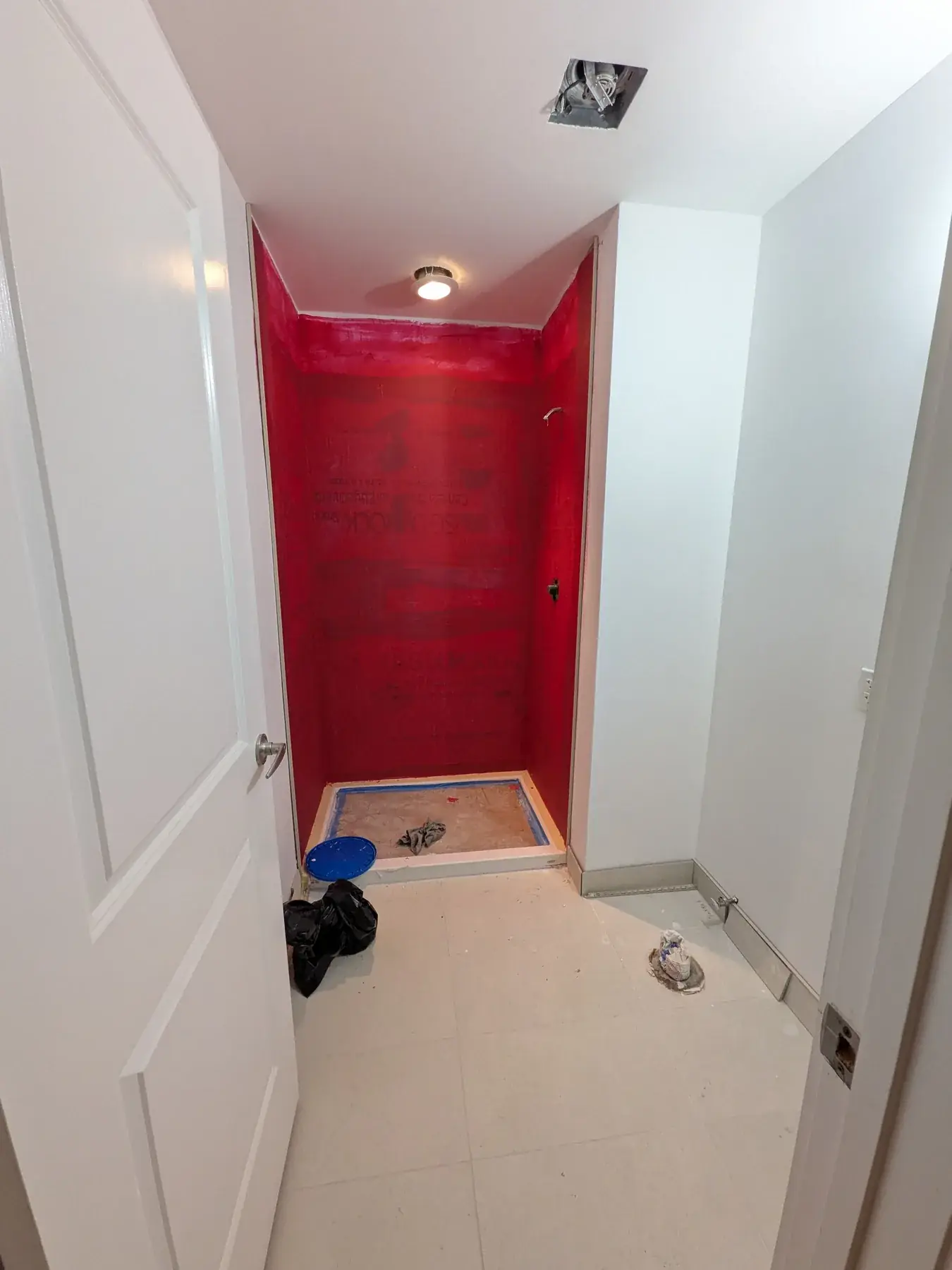 Bonded waterproofing membrane applied to the shower walls and pan before tiling