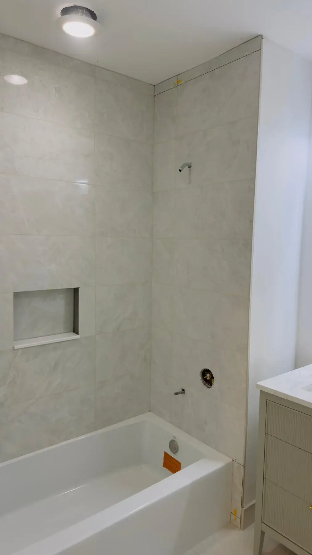 Finished tiled surround with the new tub and vanity in place