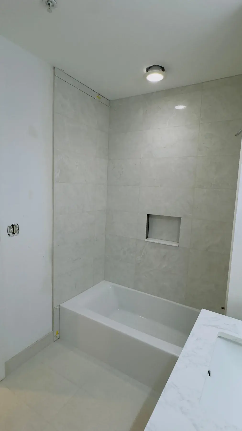 Tiled shower niche and surround in the first bathroom