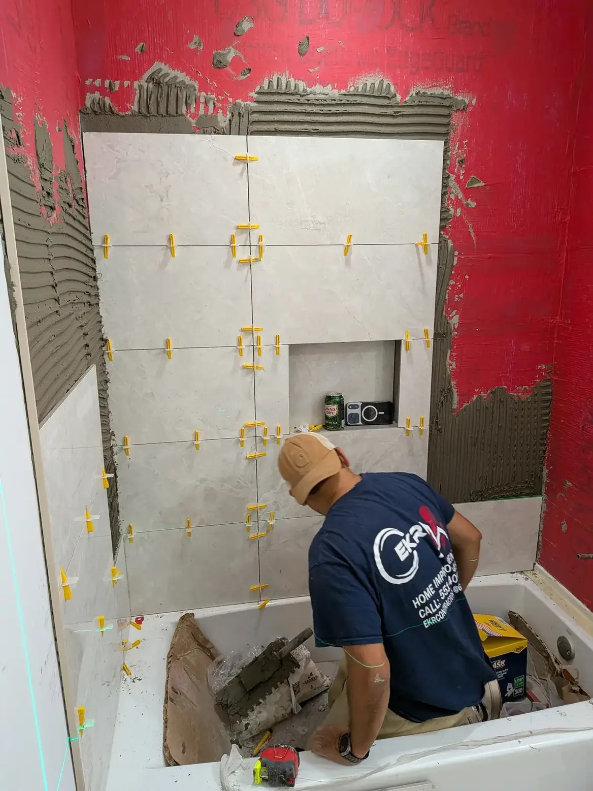 Large-format tile being set over the waterproofed shower wall