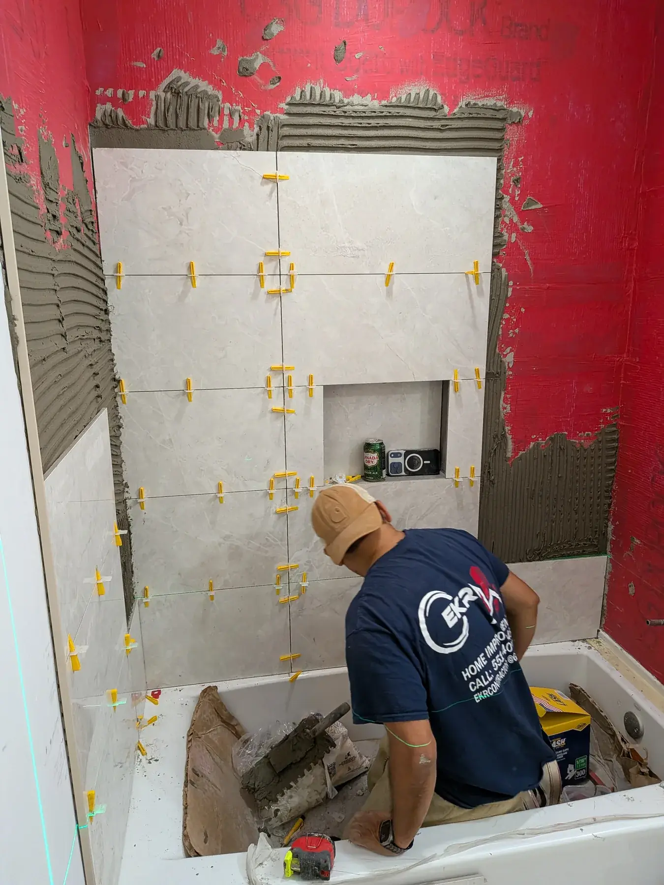 Large-format tile being set over the waterproofed shower wall