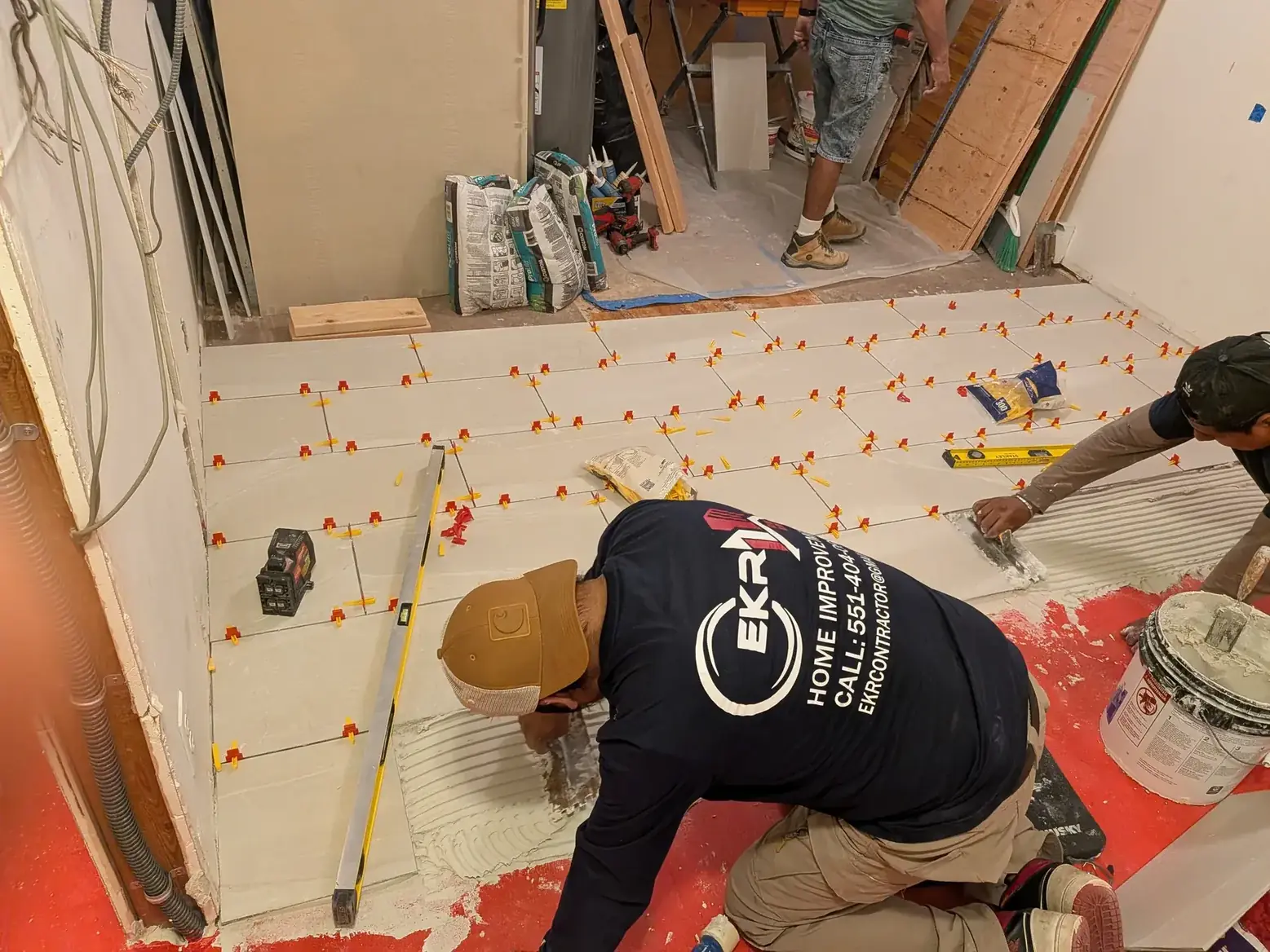 The crew setting tile over the new uncoupling membrane
