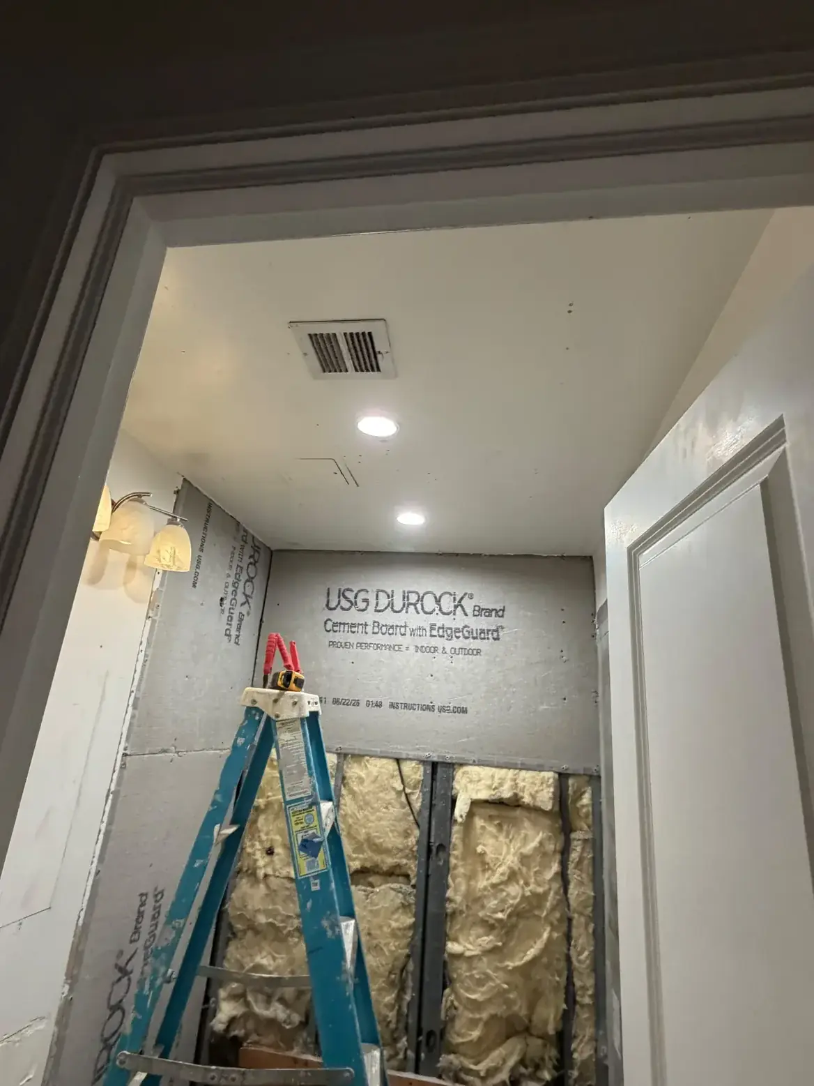 New cement board going up on the wet wall before tiling