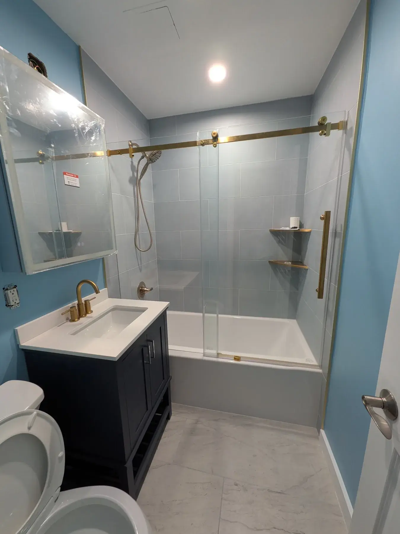 The new tub and glass panel in the completed bathroom