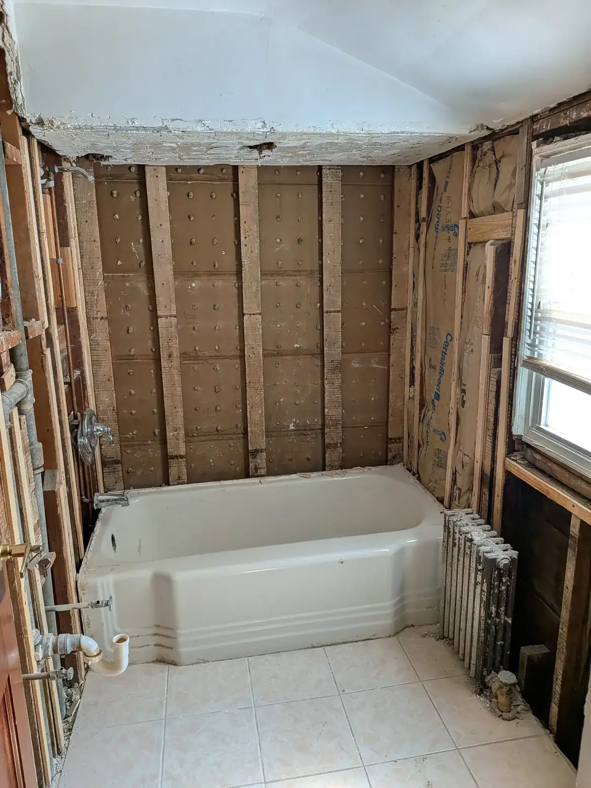 Framing, pipework and insulation exposed after demolition